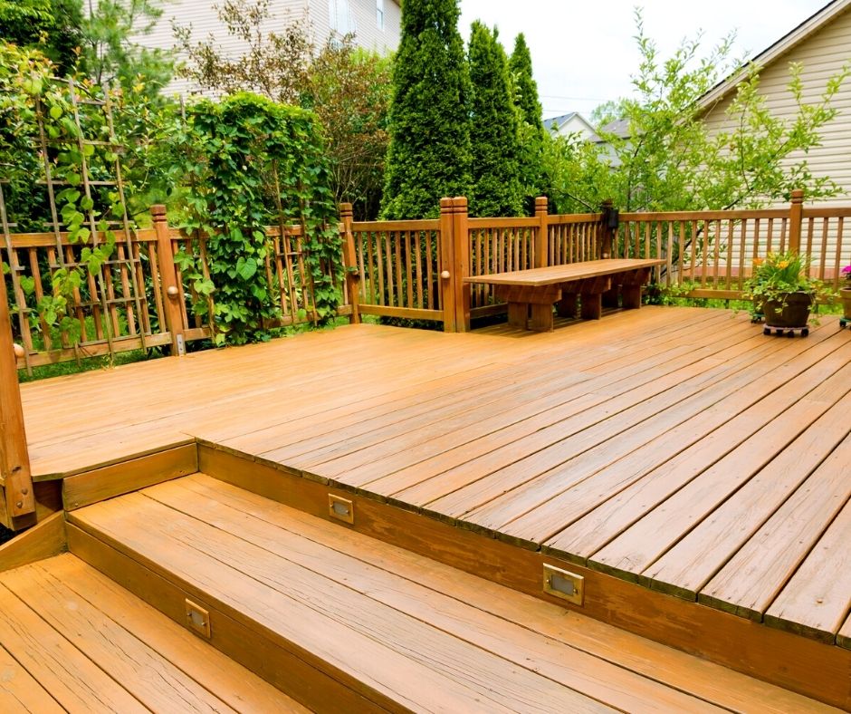 A custom deck surrounded by landscaping. Midwest Builders offers a variety of types of custom decks.